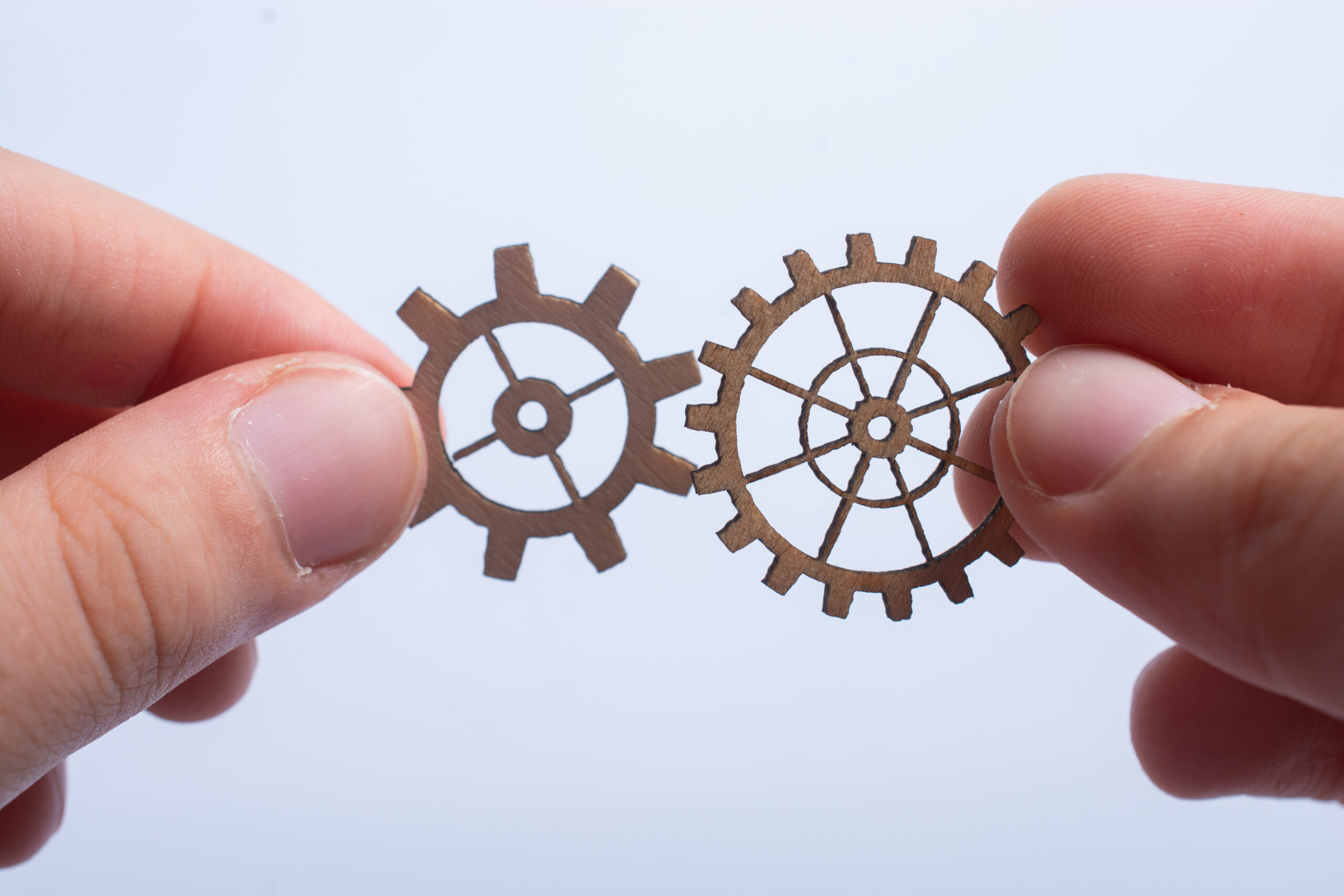 two hands connects two round gear wheels representing change in career