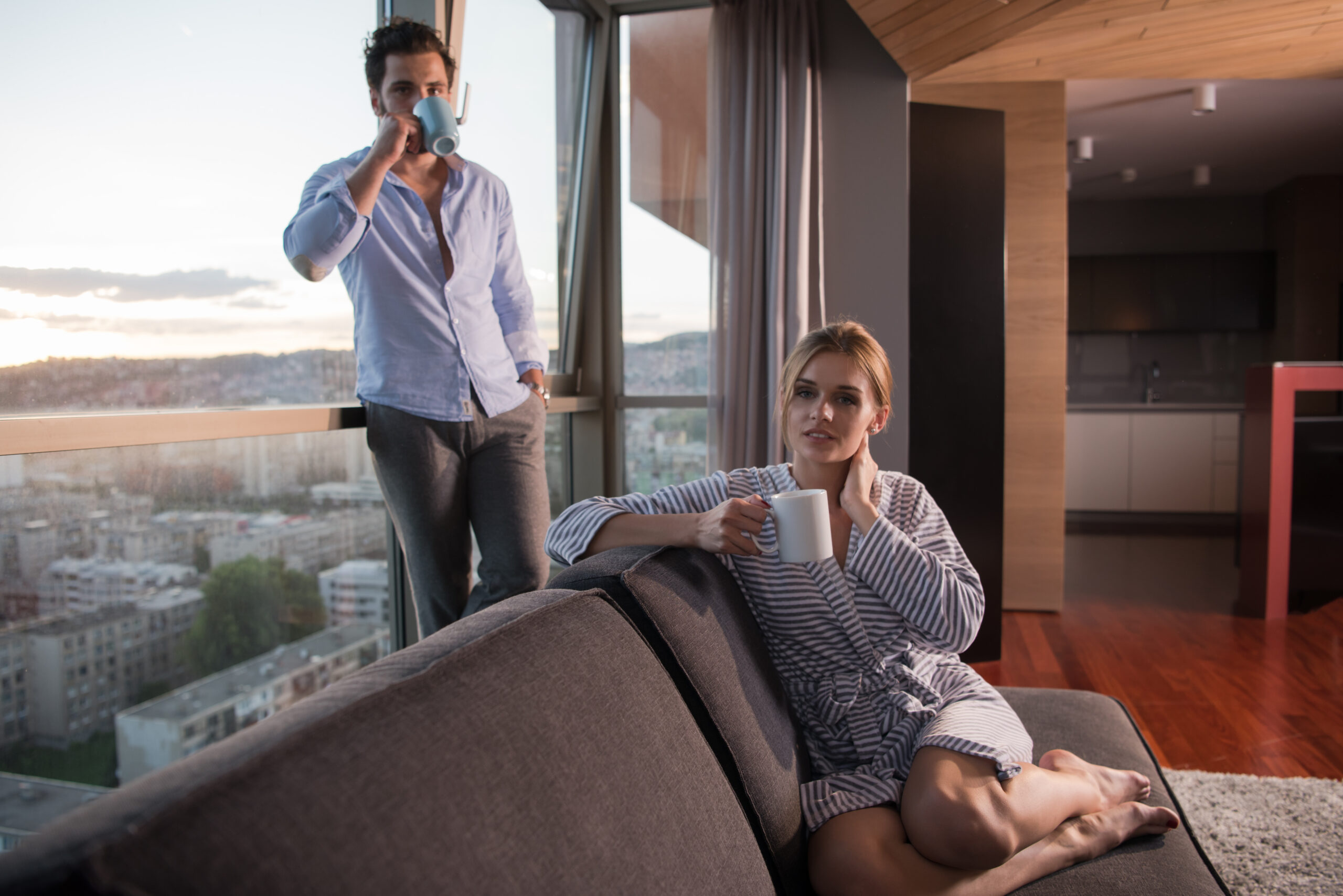 Renting Versus Buying: romantic-happy-young-couple-enjoying-evening-coffee-beautiful-sunset-landscape-city-while-standing-by-window