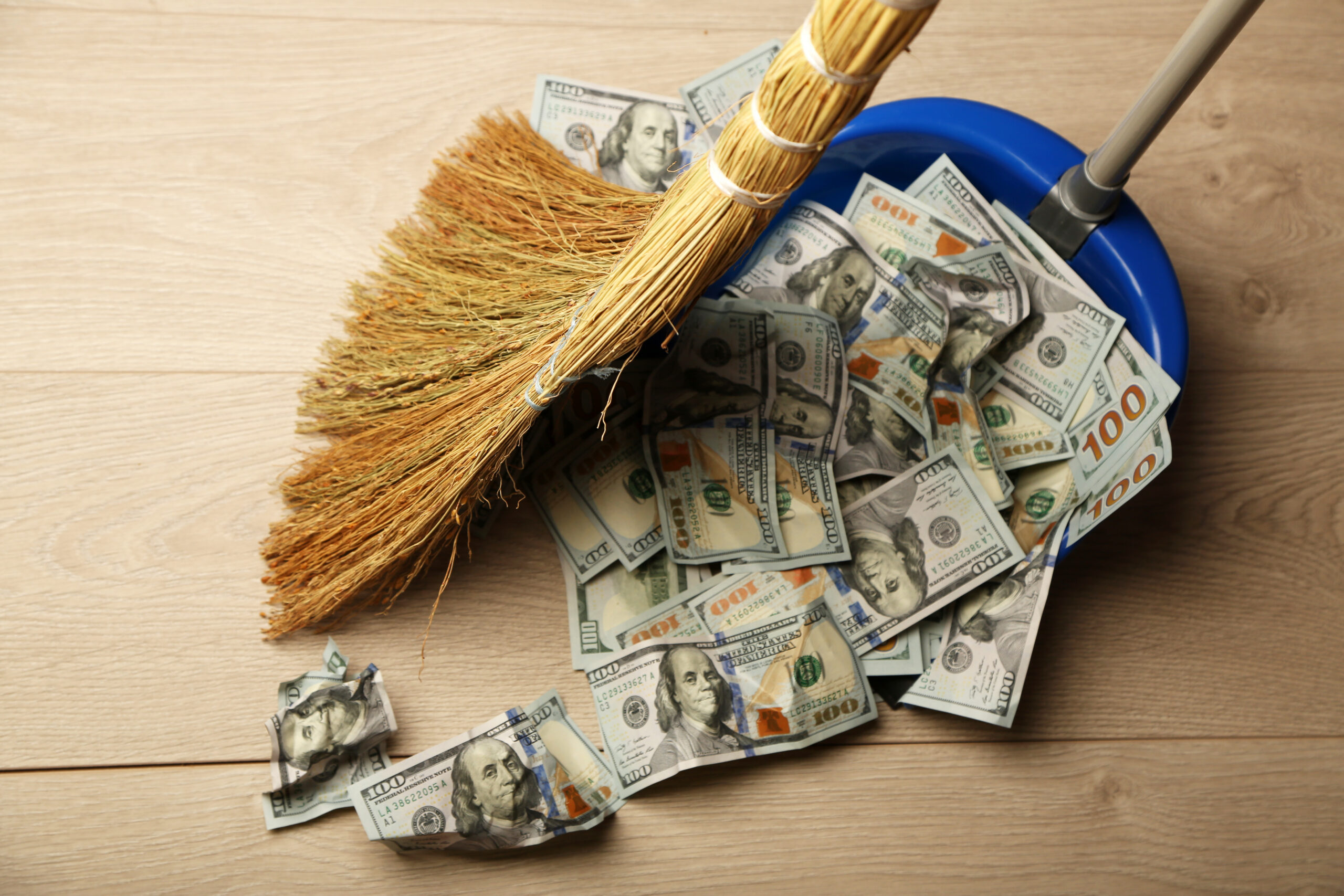 Liquidity Sweep: broom sweeps dollars scoop wooden floor background